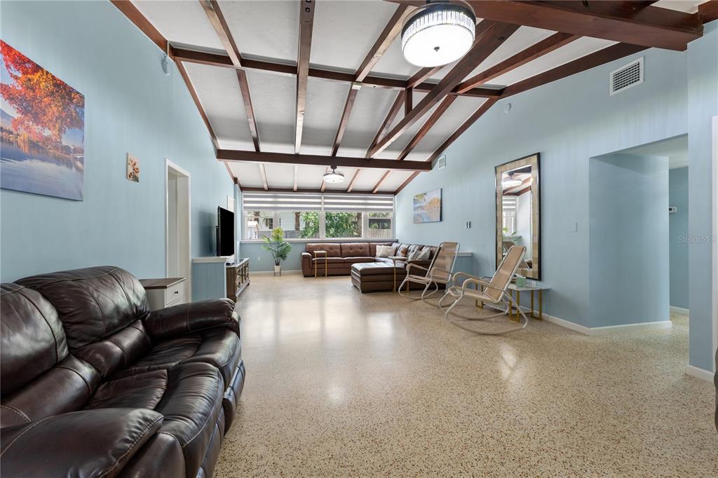 A spacious living room features light blue walls, a vaulted beamed ceiling, and terrazzo flooring — 138 PEARL AVENUE, SARASOTA, FL