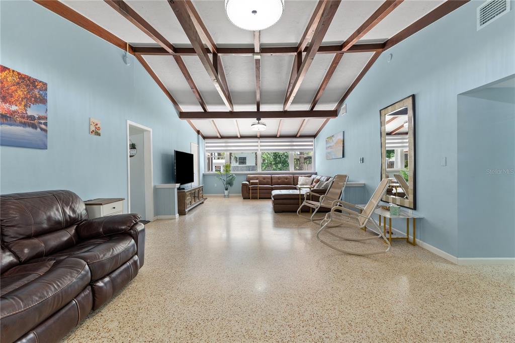 A living room features light blue walls, a vaulted beamed ceiling, and terrazzo flooring — 138 PEARL AVENUE, SARASOTA, FL