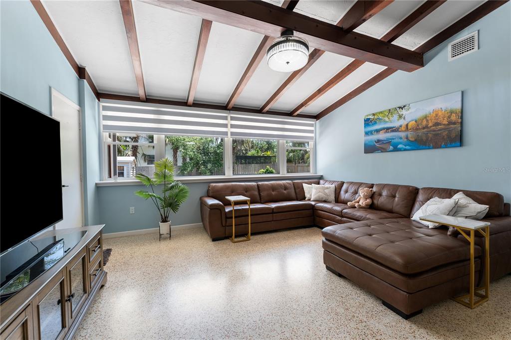A living room features a large brown sectional sofa, exposed ceiling beams, and terrazzo flooring — 138 PEARL AVENUE, SARASOTA, FL