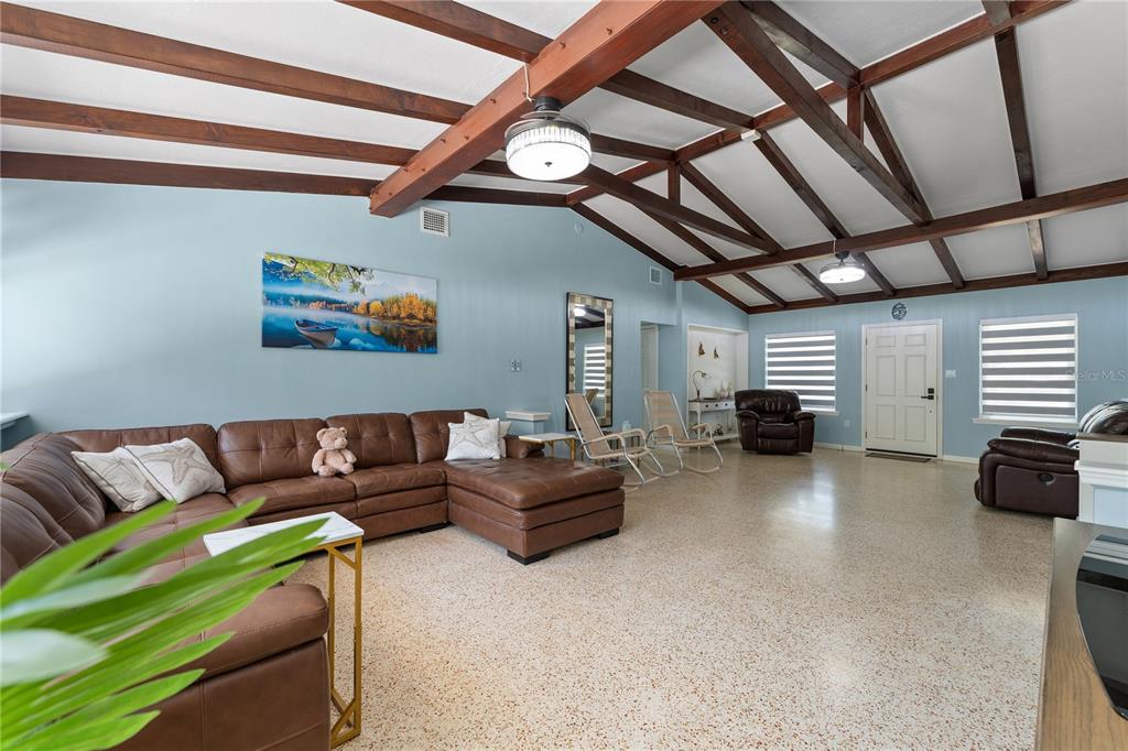 A spacious living room features a vaulted ceiling with exposed beams and light blue walls — 138 PEARL AVENUE, SARASOTA, FL