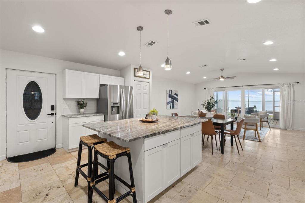 A kitchen with a large marble-topped island, white cabinetry, and an open view of water — 2462 FORT LANE ROAD, GENEVA, FL