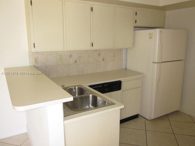 A kitchen features white cabinets, a double sink, a dishwasher, and a white refrigerator — 8853 SW 112 PL, Miami FL 33176, MIAMI, FL