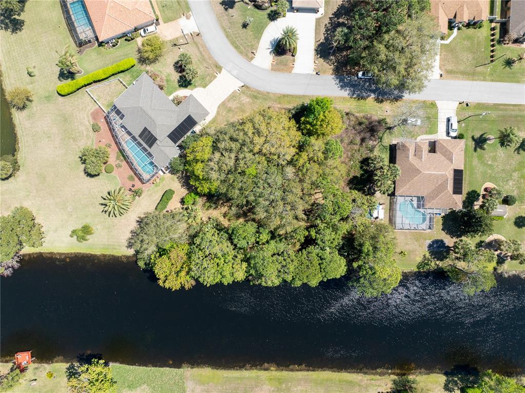 An aerial view shows two houses with swimming pools separated by a wooded lot — 37 LUDLOW LANE W, PALM COAST, FL
