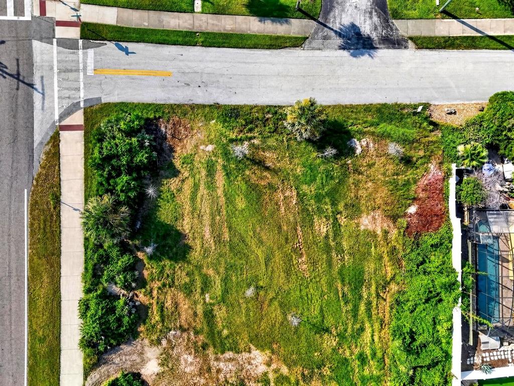 An aerial view shows a vacant, grassy corner lot bordered by sidewalks and a road — 4736 S ATLANTIC AVENUE, PONCE INLET, FL