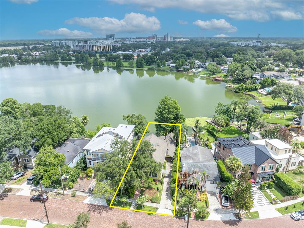 An aerial view shows a house with a yellow outline situated on a lakefront lot — 705 TERRACE BOULEVARD, ORLANDO, FL