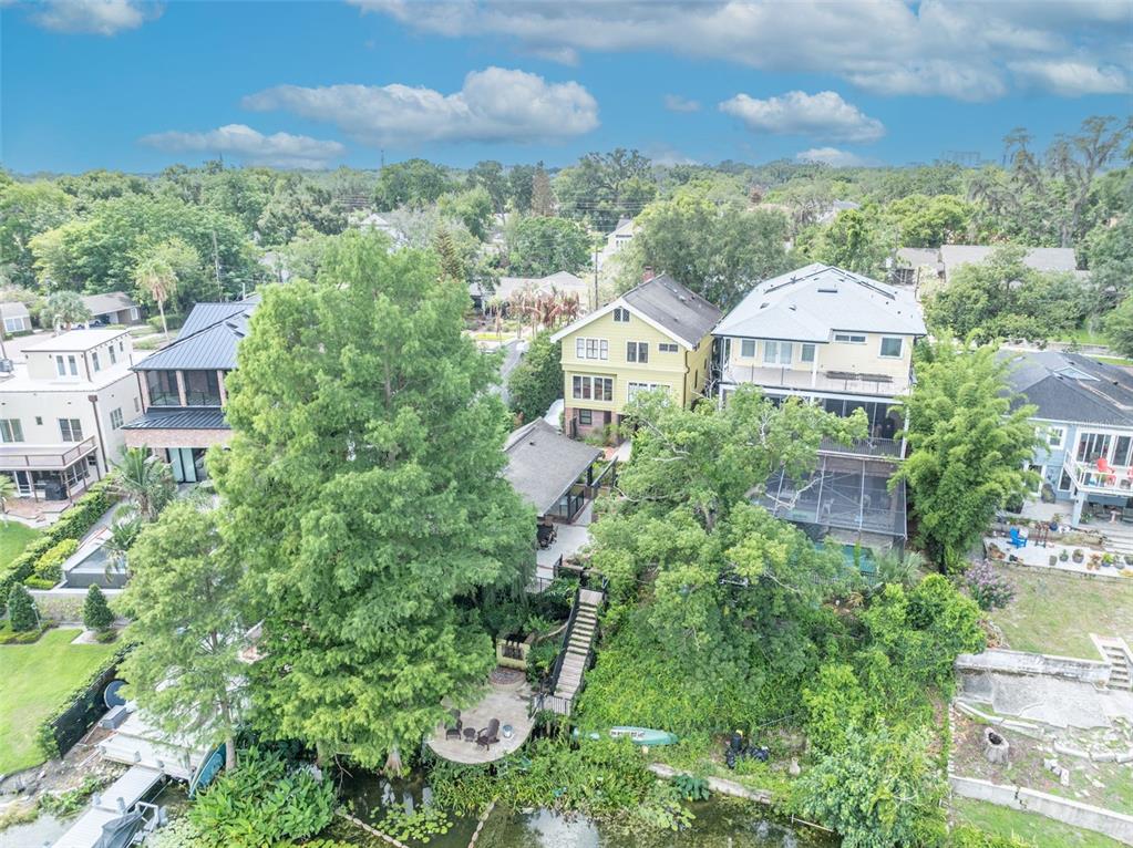 An aerial view shows several houses along a waterfront with trees and a small dock — 705 TERRACE BOULEVARD, ORLANDO, FL