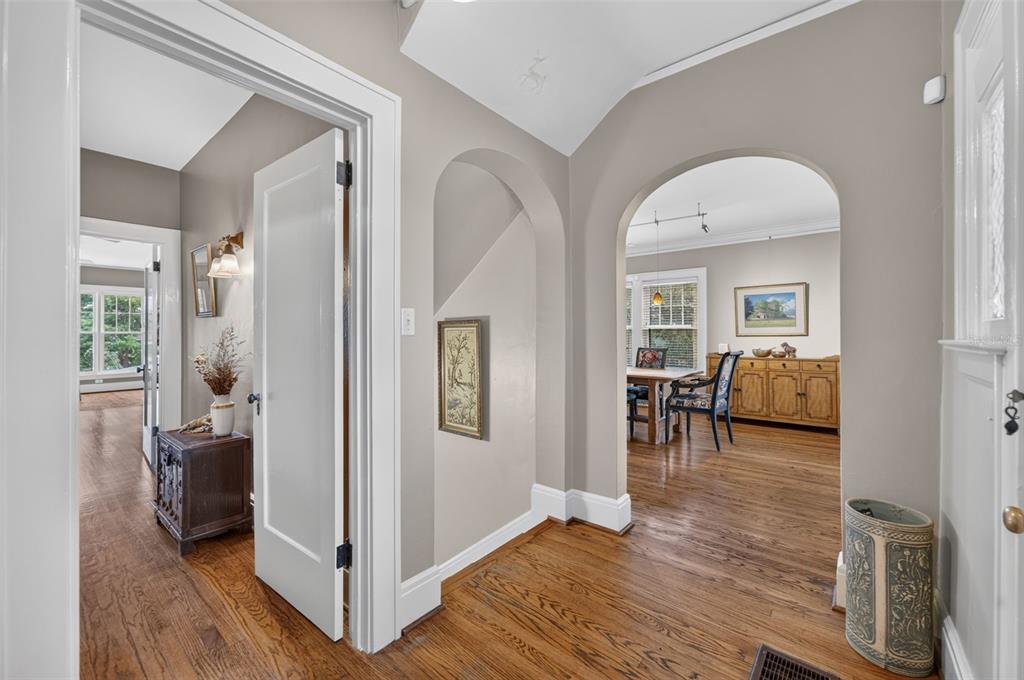 An interior view of a hallway with arched doorways, hardwood floors, and neutral wall paint — 705 TERRACE BOULEVARD, ORLANDO, FL