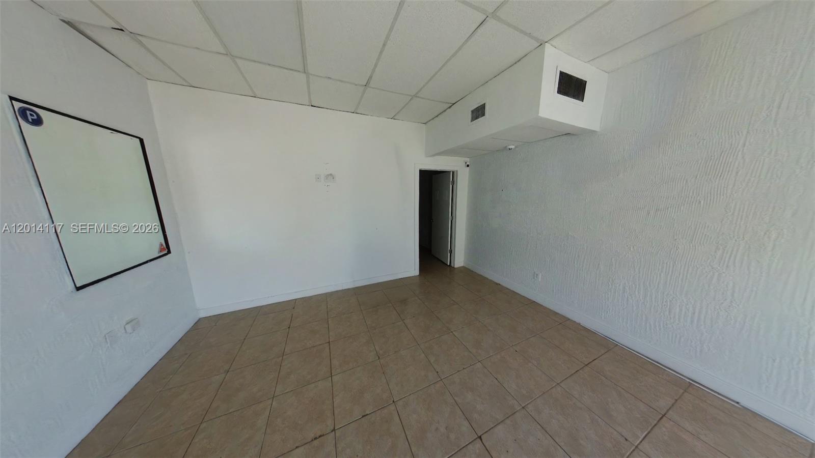 An empty room features white walls, a drop ceiling, and light-colored square floor tiles — 2319 NW 7th St # 2319, Miami FL 33125, MIAMI, FL