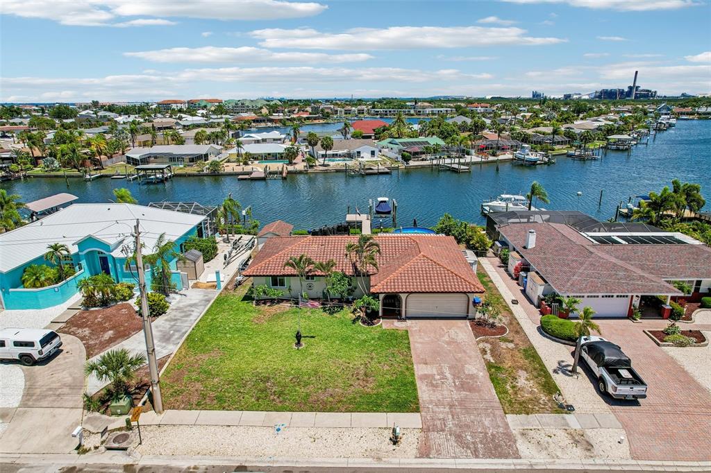 An aerial view shows a waterfront house with a tiled roof and a grassy yard — 801 FLAMINGO DRIVE, APOLLO BEACH, FL