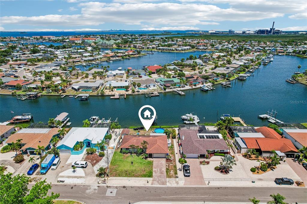 An aerial view shows a waterfront house with a pool and a tiled roof — 801 FLAMINGO DRIVE, APOLLO BEACH, FL