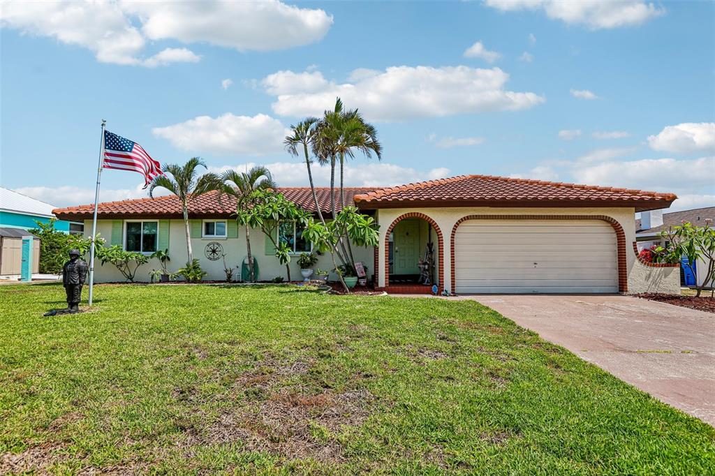 A single-story house with a tile roof, a two-car garage, and an American flag — 801 FLAMINGO DRIVE, APOLLO BEACH, FL
