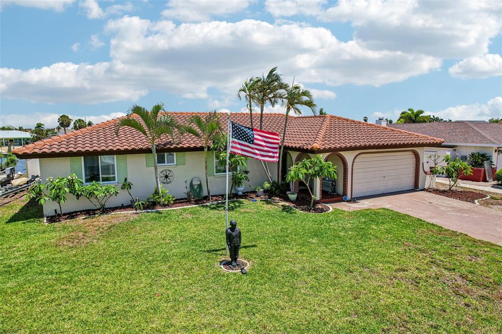 A single-story house with a tile roof, a front lawn, and an American flag — 801 FLAMINGO DRIVE, APOLLO BEACH, FL