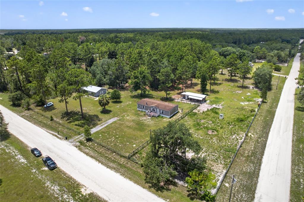 An aerial view shows a house, two outbuildings, and a fenced yard on a rural lot — 5730 SE 120TH AVENUE, MORRISTON, FL