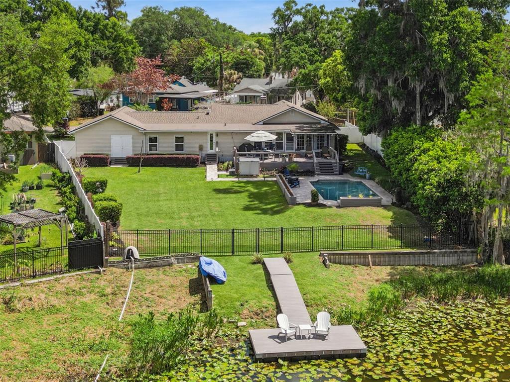 An aerial view of a house with a backyard pool, lawn, and private boat dock — 2100 MAE STREET, ORLANDO, FL