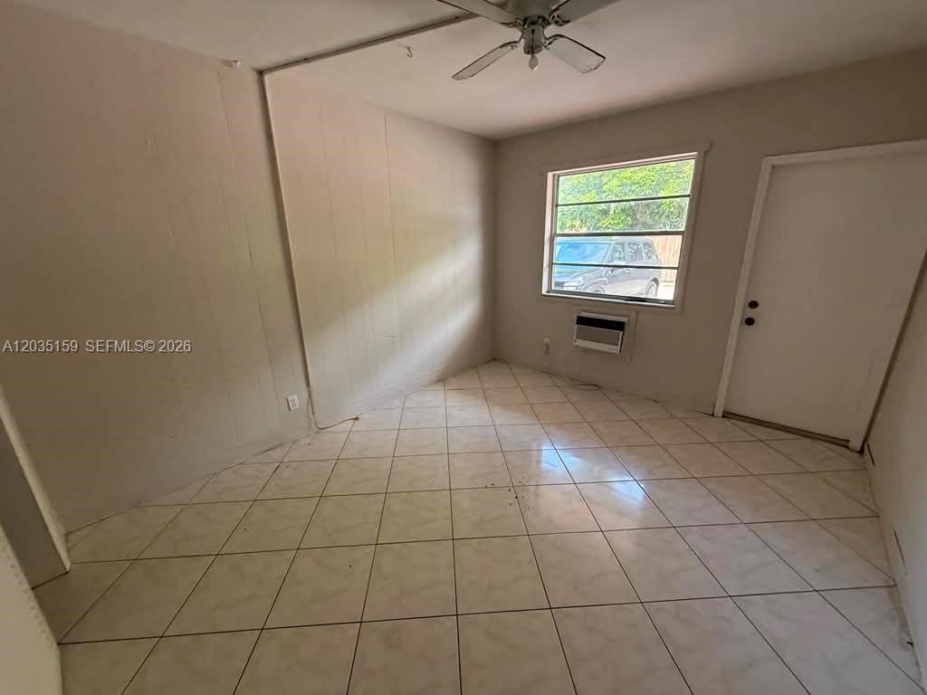 An empty room features white walls, a ceiling fan, a window, and light-colored tile flooring — 2917 Plunkett St # 15C, Hollywood FL 33020, HOLLYWOOD, FL