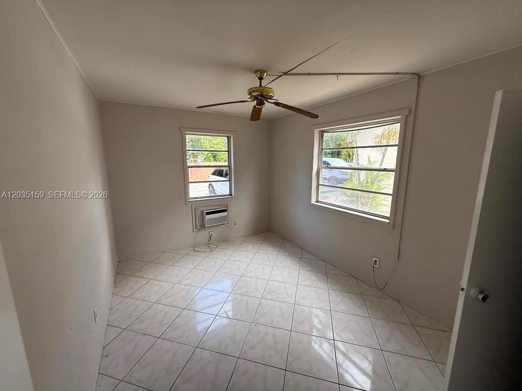 A room with white walls, tiled floors, a ceiling fan, and two windows — 2917 Plunkett St # 15C, Hollywood FL 33020, HOLLYWOOD, FL