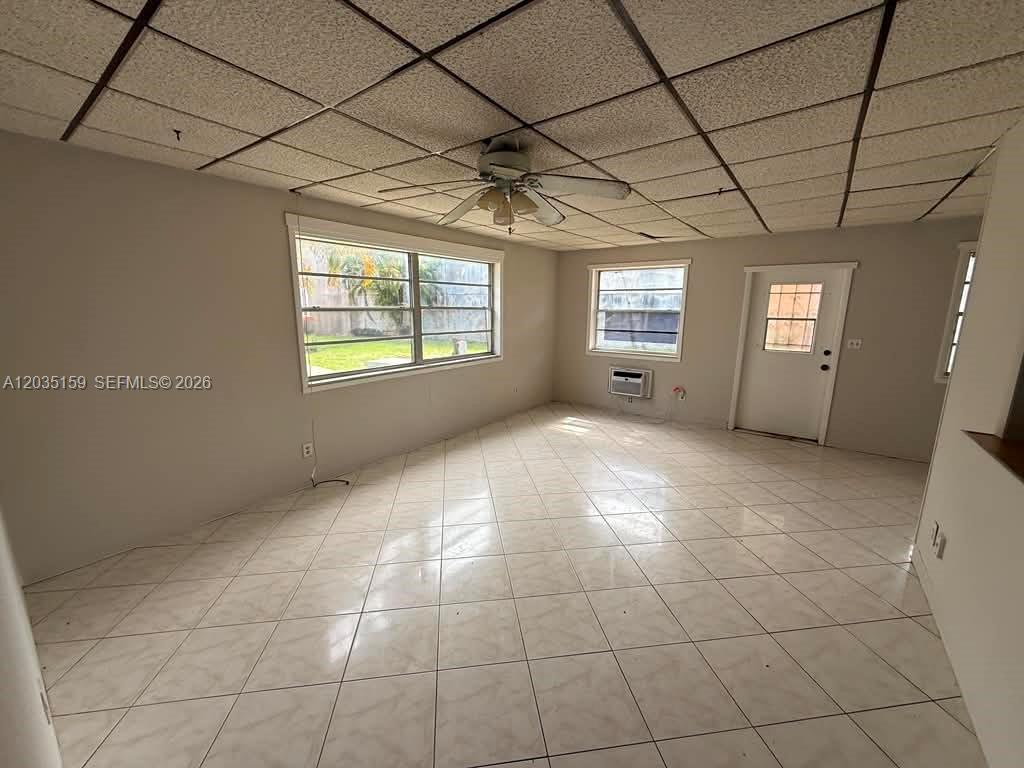A living room features white tile flooring, a drop ceiling, and a ceiling fan — 2917 Plunkett St # 15C, Hollywood FL 33020, HOLLYWOOD, FL