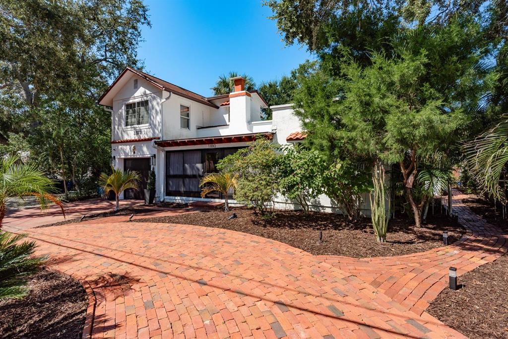 A two-story white house with a brick driveway and a screened-in front porch — 1880 N WASHINGTON AVENUE, CLEARWATER, FL