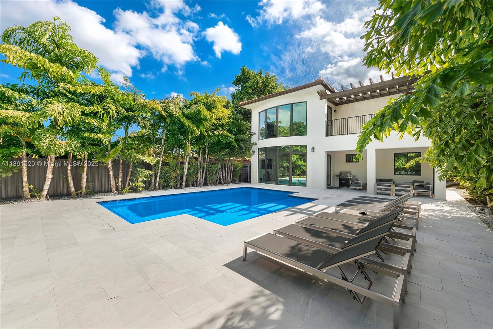 A two-story house with a swimming pool, lounge chairs, and palm trees in the backyard — 6529 SW 30th St, Miami FL 33155, MIAMI, FL