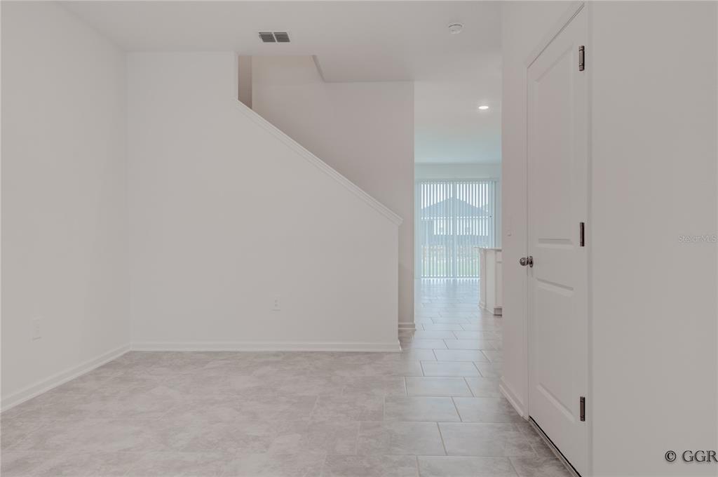 A view of a tiled entryway with a staircase and a closed white door — 3243 LAURENT LOOP, DAVENPORT, FL