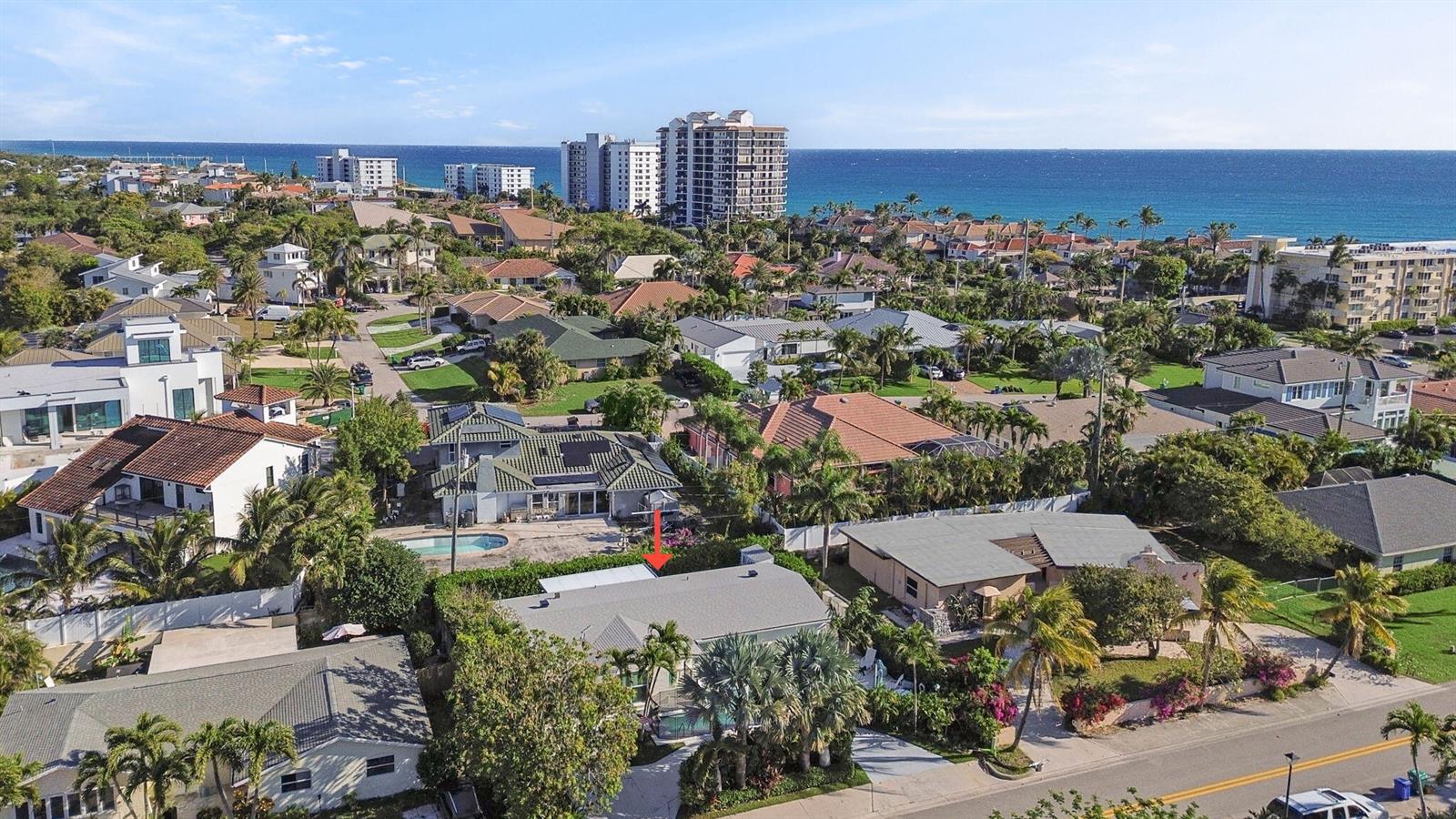 An aerial view shows a residential neighborhood with houses, swimming pools, and the ocean nearby — 471 Mars Way, Juno Beach FL 33408, JUNO BEACH, FL