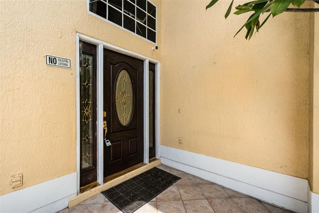 A front entryway features a dark wood door with a glass oval insert and sidelights — 12422 SION COURT, ORLANDO, FL