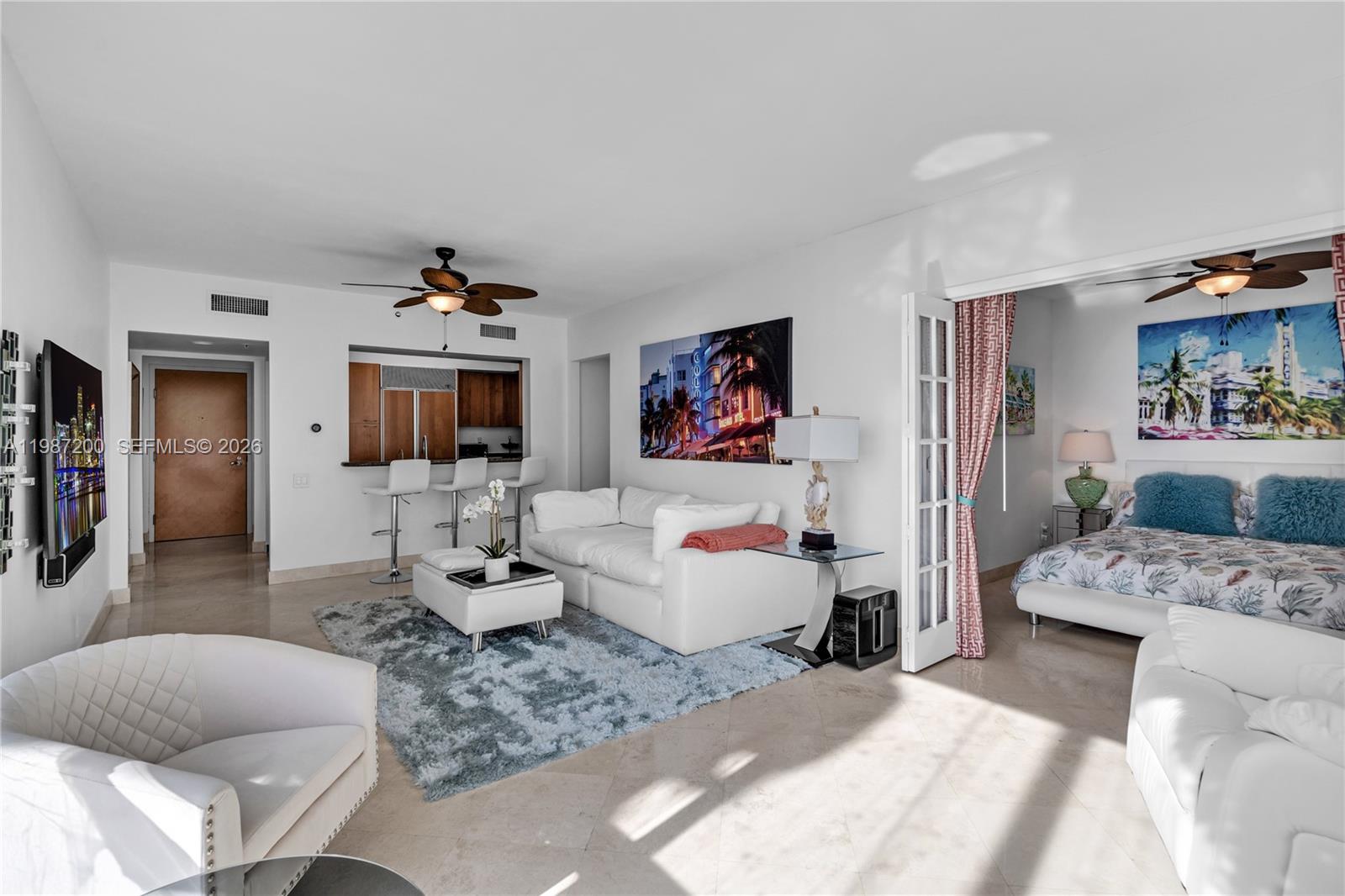 A living room with a white sofa, a shag rug, and an adjacent bedroom area — 1500 Ocean Dr # 907, Miami Beach FL 33139, MIAMI BEACH, FL