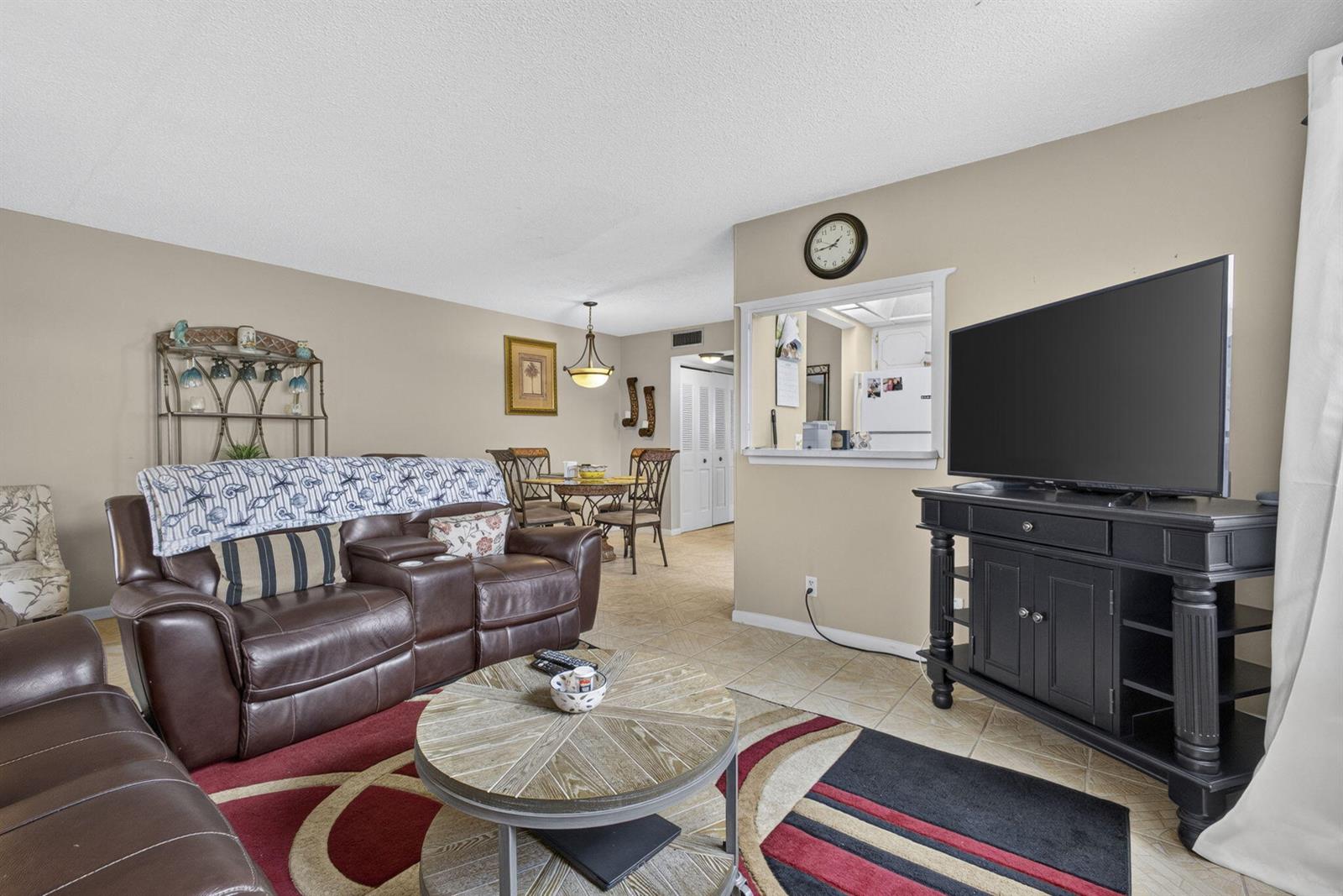 A living room features a brown leather sofa, a round coffee table, and a television — 5 Northampton A # 5, West Palm Beach FL 33417, WEST PALM BEACH, FL