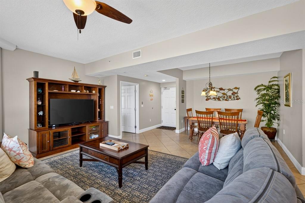 A living room with a television console, coffee table, sofa, and adjacent dining area — 3799 S ATLANTIC AVENUE UNIT 601, DAYTONA BEACH SHORES, FL