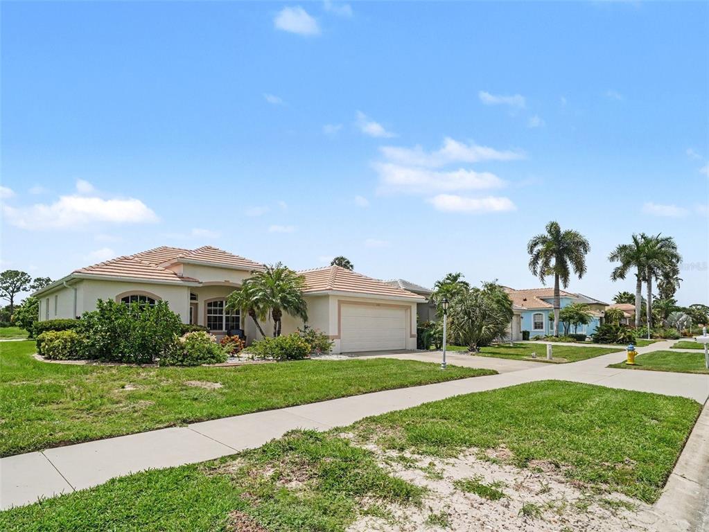 A single-story house with a tiled roof and a two-car garage sits on a lawn — 2885 ROYAL PALM DRIVE, NORTH PORT, FL