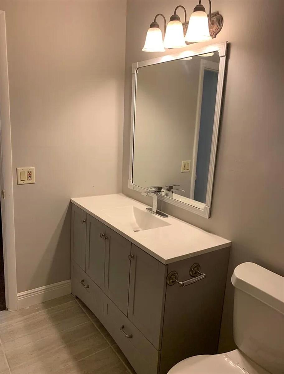 A bathroom features a gray vanity with a white countertop, a mirror, and overhead lighting — 22324 SW 57th Circle, Boca Raton FL 33428, BOCA RATON, FL