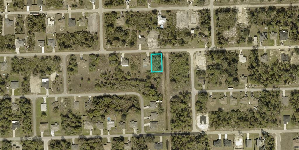 An aerial view shows a vacant, rectangular lot outlined in blue within a residential neighborhood — 2709 53RD STREET W, LEHIGH ACRES, FL