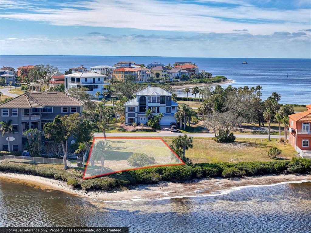 An aerial view shows a vacant waterfront lot outlined in red near coastal homes — Lot 46 HARBORPOINTE DR., PORT RICHEY, FL