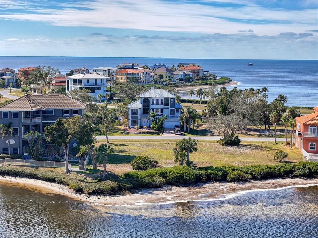 An aerial view shows coastal homes situated along a shoreline with trees and water — Lot 46 HARBORPOINTE DR., PORT RICHEY, FL