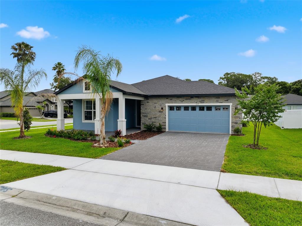 A single-story house with blue siding, a stone facade, and a two-car garage — 117 HADLEY DRIVE, SANFORD, FL