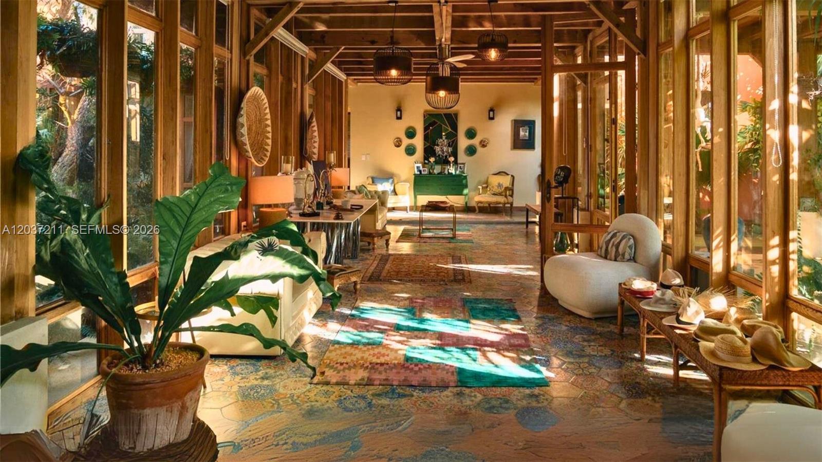 A sunroom with floor-to-ceiling windows, tiled floors, wooden beams, and various seating areas — 0 Las iguanas, FL