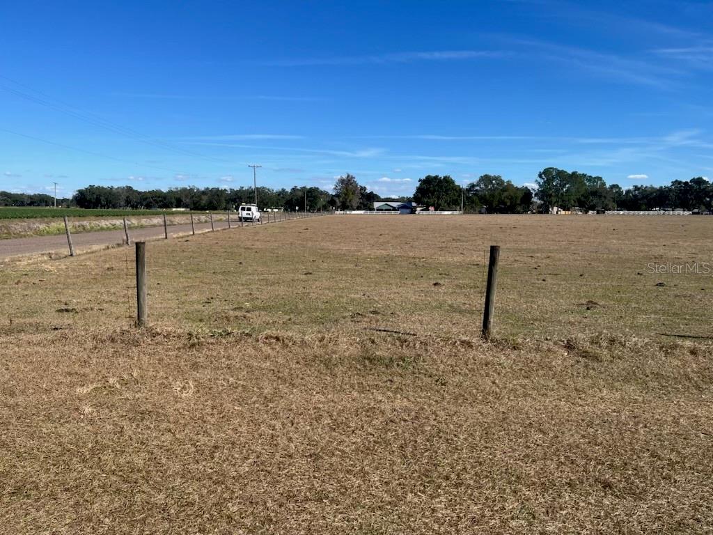 A wide, dry, fenced-in grassy field under a clear blue sky — 0 BOB HEAD ROAD, PLANT CITY, FL