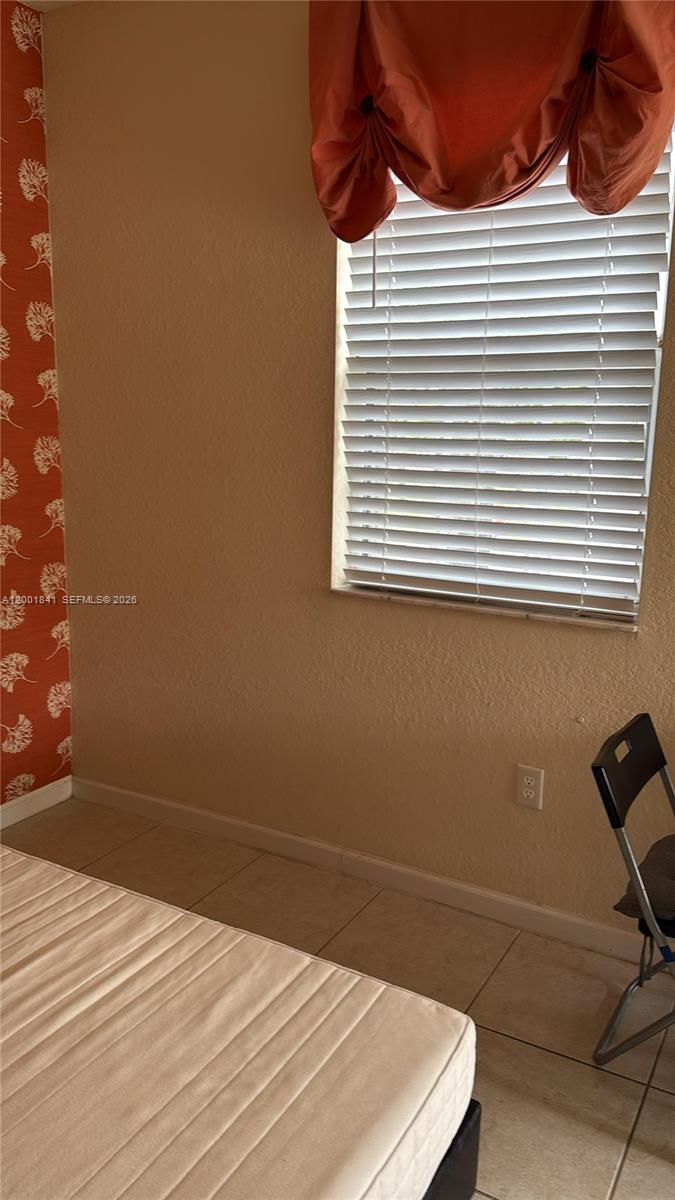 A bedroom features a mattress, a window with blinds and orange valance, and patterned wallpaper — 16961 SW 90th Ter, Miami FL 33196, MIAMI, FL