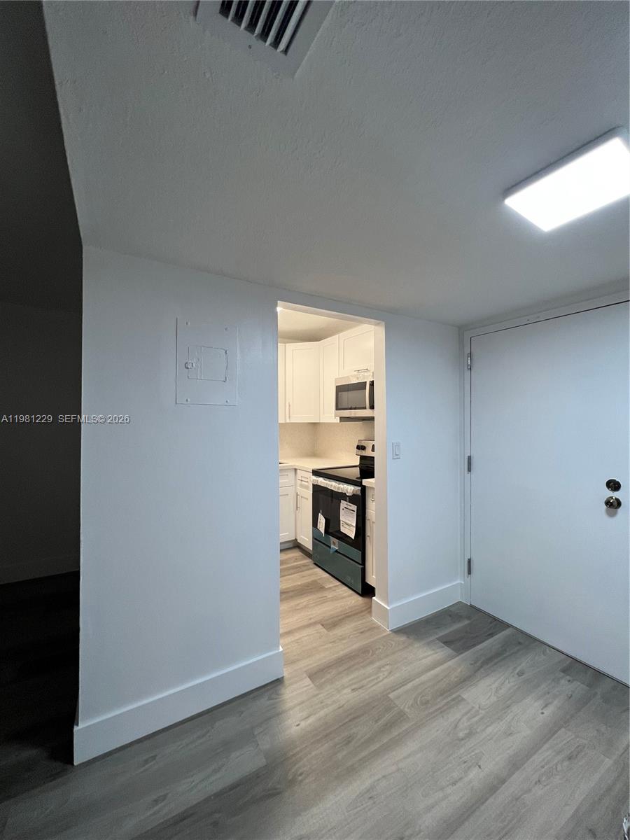 A kitchen features white cabinets, light-colored speckled countertops, a stainless steel sink, and a refrigerator — 5050 NW 7th St # 511, Miami FL 33126, MIAMI, FL
