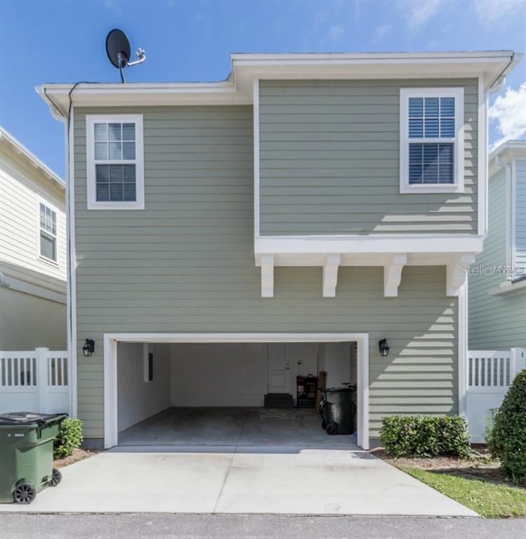 The exterior of a two-story house features sage green siding, a two-car garage, and a satellite dish — 1596 CASTILE STREET, CELEBRATION, FL