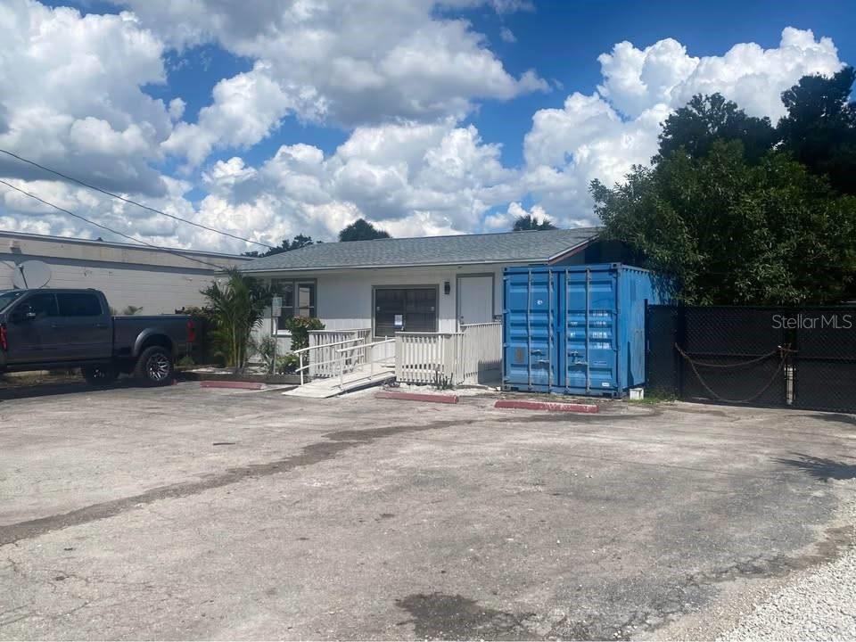 A single-story building with a wheelchair ramp and a blue shipping container in the lot — 1254 PINEY ROAD, NORTH FORT MYERS, FL