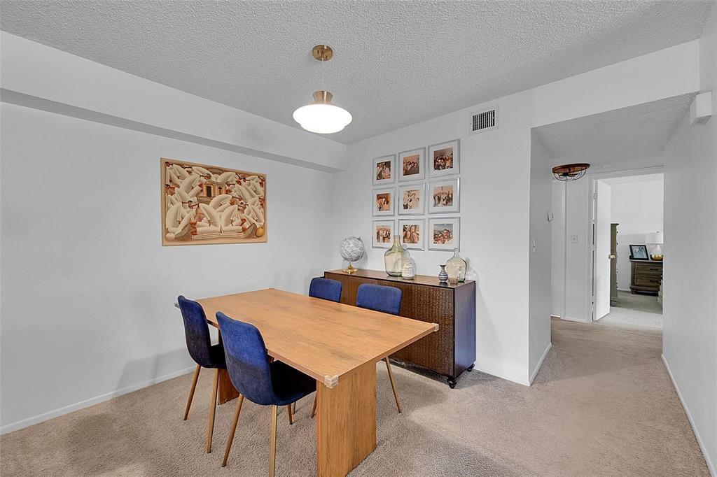 A dining room features a wooden table, four blue chairs, and a matching sideboard — 117 Gardens Drive # 204, Pompano Beach FL 33069, POMPANO BEACH, FL