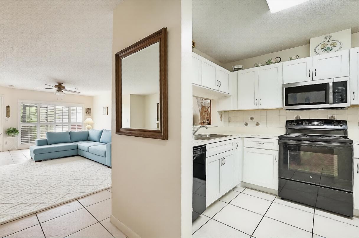 A view from a tiled kitchen into a living room with a blue sectional sofa — 405 Harbour Pointe Way, FL 33413, FL
