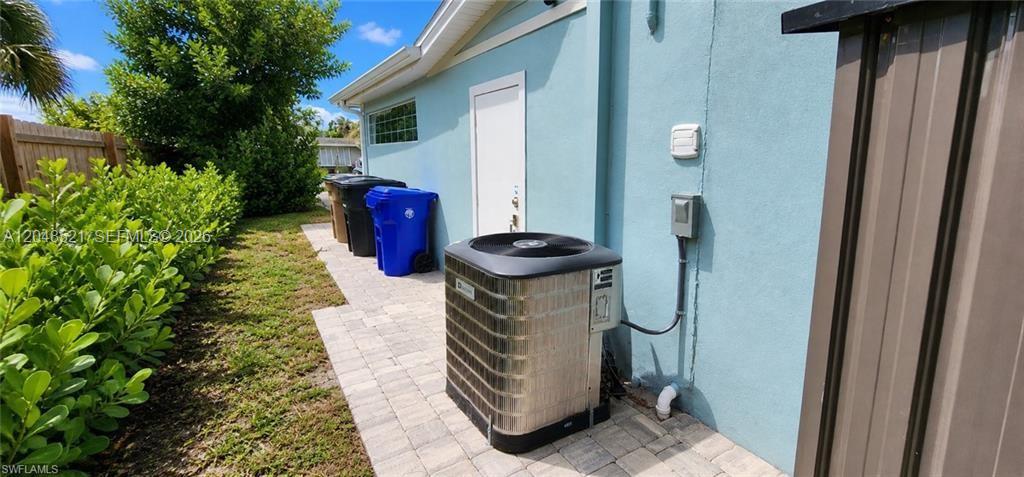 An outdoor view shows an air conditioning unit on a paved path beside a house — FORT MYERS, FL