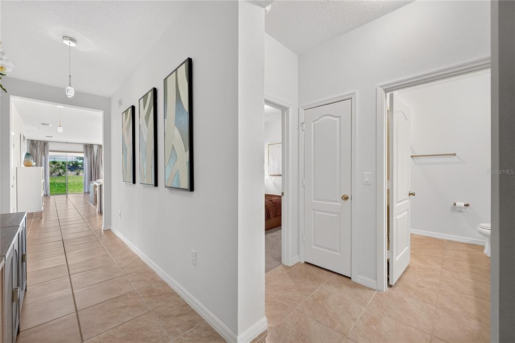 A tiled hallway leads to an open living area with three framed wall art pieces — 415 OVERPOOL AVENUE, DAVENPORT, FL