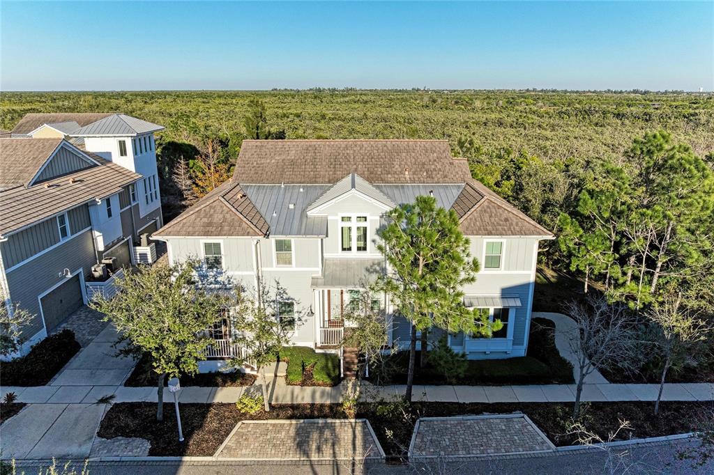 An aerial view of a two-story light blue house with a metal and shingle roof — 339 SAPPHIRE LAKE DRIVE UNIT 201, BRADENTON, FL