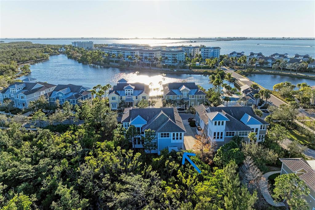 An aerial view shows a blue multi-story residential building surrounded by lush green trees — 339 SAPPHIRE LAKE DRIVE UNIT 201, BRADENTON, FL