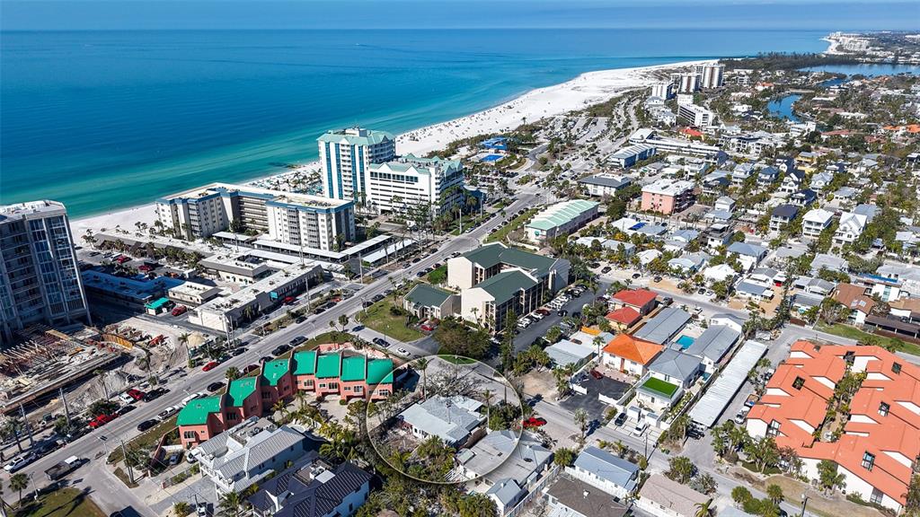 An aerial view shows a residential area near a beach with a circled single-story house — 132 HARRISON DRIVE, SARASOTA, FL