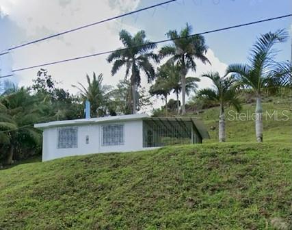 A white, single-story house sits on a grassy hillside surrounded by several palm trees — KM 12.2 INT LAS PAPAYAS RD (SR-185) Lots A and B, CAROLINA, PR