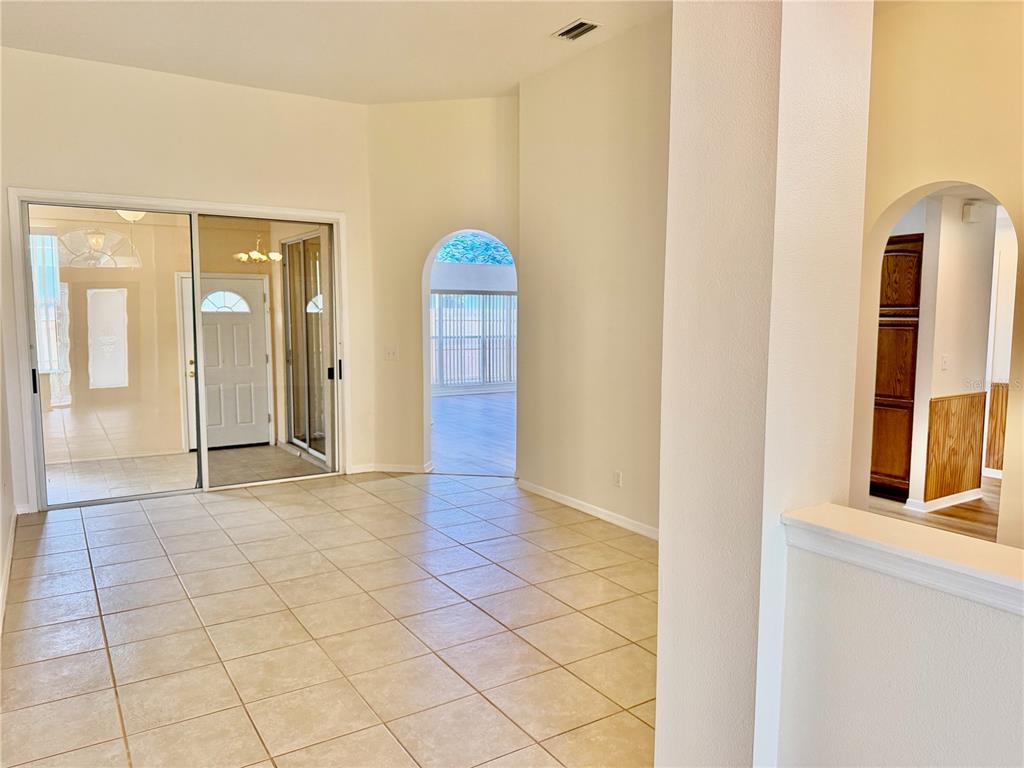 A tiled room features a sliding glass door, an arched doorway, and a partial wall — 1959 WOOD TRAIL STREET, TARPON SPRINGS, FL